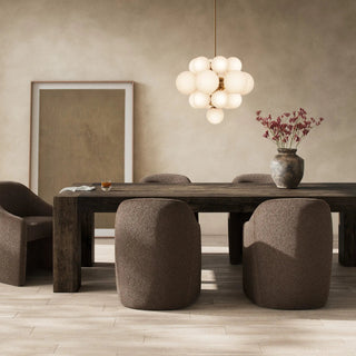 A modern dining space featuring the Abaso Dining Table, styled with soft lighting and contemporary decor.