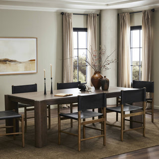 A stylish dining room setup with the Soho Dining Table, complemented by warm lighting and modern decor.