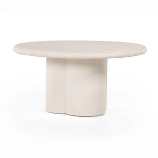 Full view of the Grano Dining Table, a white-finished concrete table with a rounded top and clover-shaped base.