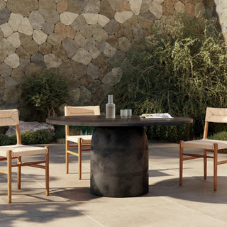 A stylish outdoor dining area featuring the Basil Dining Table, set in a natural environment for a contemporary look.