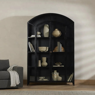 Stylish black iron metal cabinet in a modern living room, styled with books and decorative items.