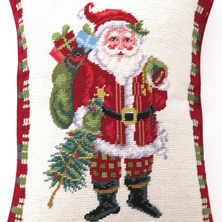 Decorative pillow with a festive design of Santa Claus holding a sack and tree.