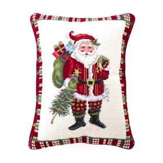Decorative pillow with a festive design of Santa Claus holding a sack and tree, on a white background.