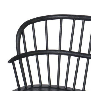 A black Windsor-style dining bench with a contemporary silhouette and finely sculpted details.