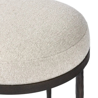 Close-up of the upholstered seat on a hammered iron accent stool, showing its soft texture and stitching.