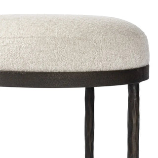 Close-up of the upholstered seat on a hammered iron accent stool, showing its soft texture and stitching.