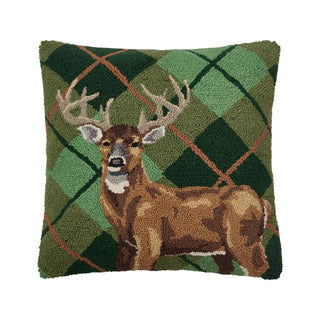 Decorative pillow with a deer design on a green plaid background