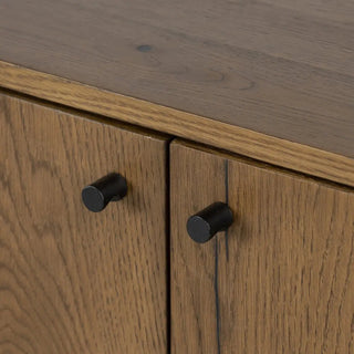 Close-up of the black metal handles on the amber oak veneer sideboard, emphasizing its modern aesthetic.