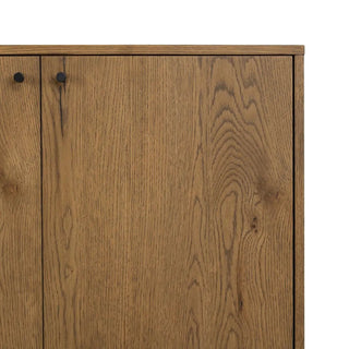 Close-up of the black metal handles on the amber oak veneer sideboard, emphasizing its modern aesthetic.