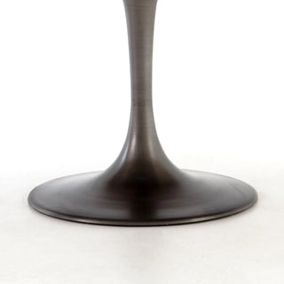 Side view of the Evans Round Dining Table, highlighting its sleek, vessel grey iron tulip-shaped base.