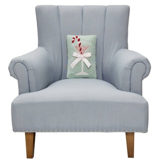 Light blue armchair with a decorative pillow featuring a cocktail design on a white background
