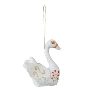 White swan ornament with red berries on a white background