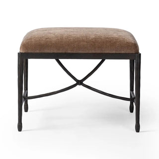 Front view of an art deco-inspired iron stool with a plush velvet seat.