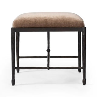 Side view of an art deco-style iron stool featuring a textured metal base and soft velvet upholstery.