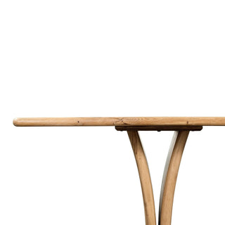 Angled perspective of the Marcon Dining Table, emphasizing its curved pedestal panels.