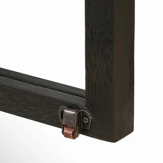 Detailed view of the black drifted oak sideboard’s metal hardware and glass door framing.