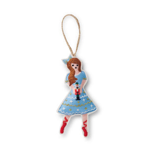 Decorative Christmas ornament of a girl in a blue dress with red shoes on a white background