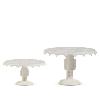 Two white decorative tables with intricate designs on a white background