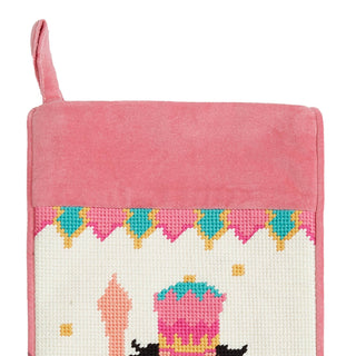 Pink cross-stitched pot holder with a castle design on a white background