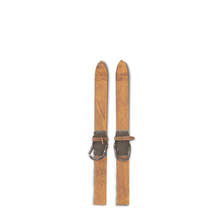 Pair of wooden skis with leather straps on a white background