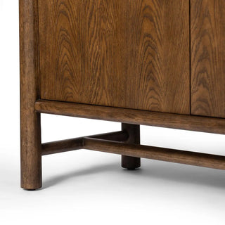 Detailed view of the legs and base of a 3-door oak and veneer cabinet in a toasted finish, highlighting its sturdy construction.