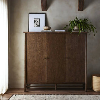 A 3-door oak and veneer cabinet in a toasted finish styled in a modern home setting, complementing a neutral and warm decor.