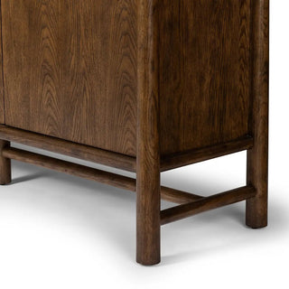 Detailed view of the legs and base of a 3-door oak and veneer cabinet in a toasted finish, highlighting its sturdy construction.