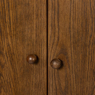 Close-up of the door handles and hardware on a 3-door oak and veneer cabinet in a toasted finish.