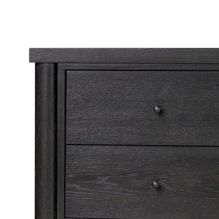 A close-up of the drawer on a black media console made of ebony oak veneer, showcasing its smooth functionality and craftsmanship.