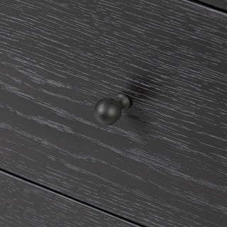 Detailed view of the sleek hardware on a black ebony oak media console, featuring minimalistic metal knobs.