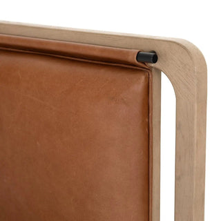 Close-up of the caramel-toned leather headboard wrapped around a black metal rod for a sophisticated touch.