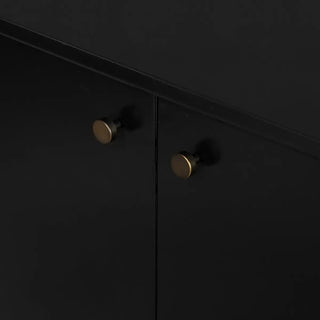 Brass knob details on a black bronzed iron sideboard, enhancing its elegant design.