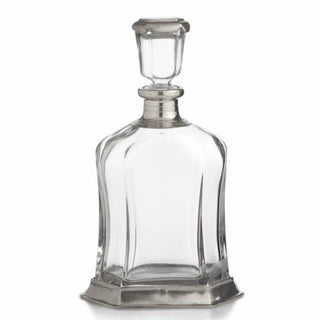 Clear glass decanter with silver stopper on a white background