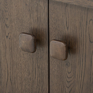 Close-up of the sturdy hinges and wood knobs on the rustic brown oak sideboard for added durability.