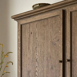 Close-up detail of the worn oak cabinet’s wood grain and natural knots.